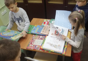 Dzieci z zainteresowaniem przeglądają książki.